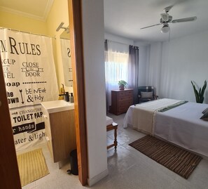 A hotel room with a bathroom, a bed, a desk, and a ceiling fan. - Villa La Yuca: private pool, outdoor barbecue, and private parking (pet-friendly) (Los Alcázares)