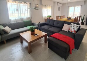 A living room with two sofas, a coffee table, and a dining area in the background. - Villa La Yuca: private pool, outdoor barbecue, and private parking (pet-friendly) (Los Alcázares)