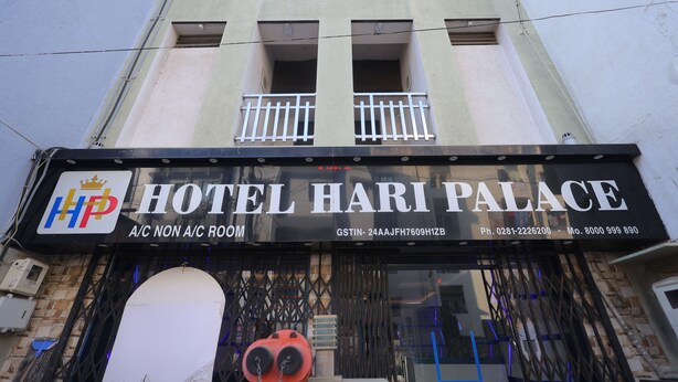 Exterior do Hotel Hari Palace com placa indicando disponibilidade de quartos com e sem ar condicionado, número de contato e endereço.