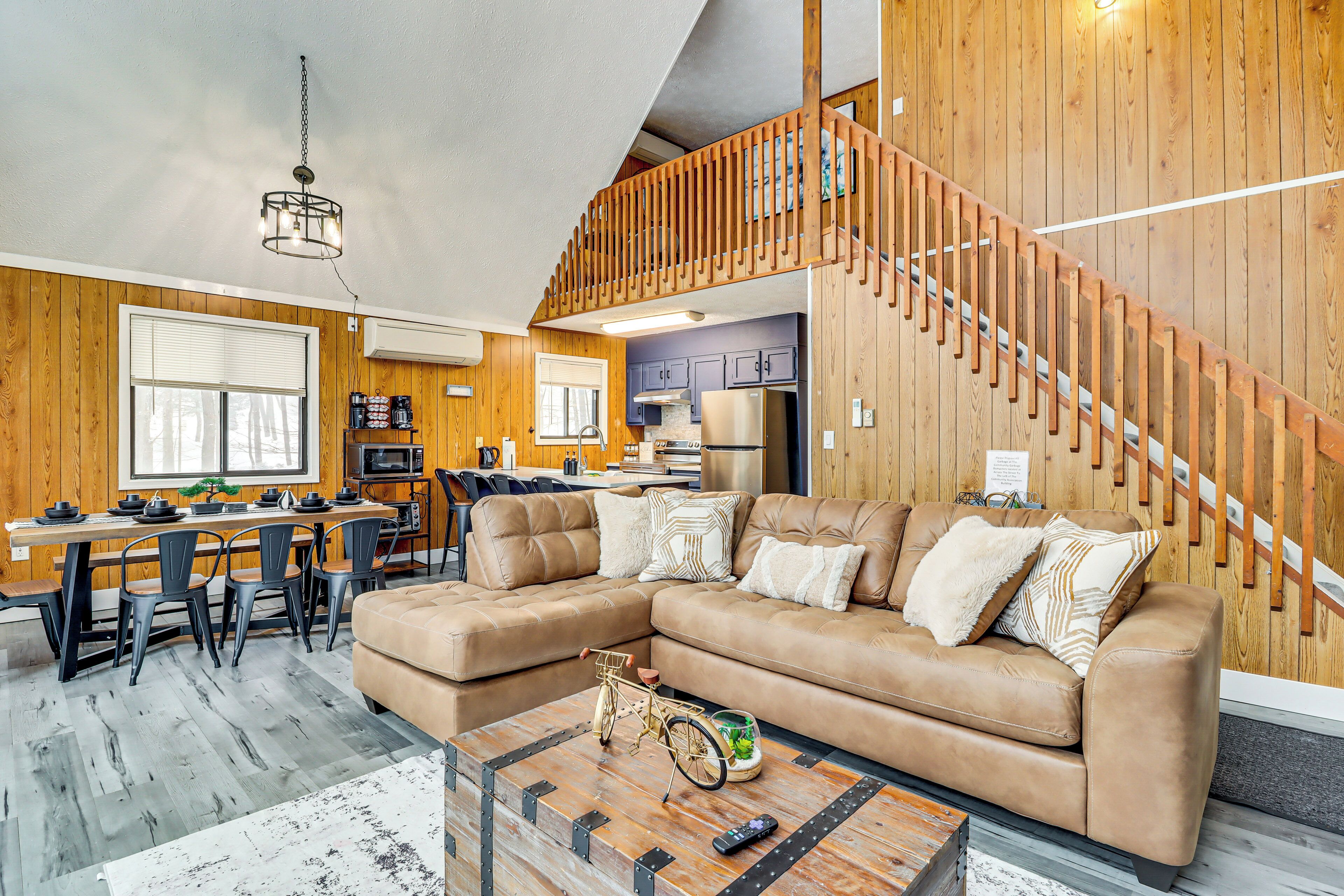 Ein modernes Wohnzimmer mit Ecksofa, Holzboden und einer Treppe.