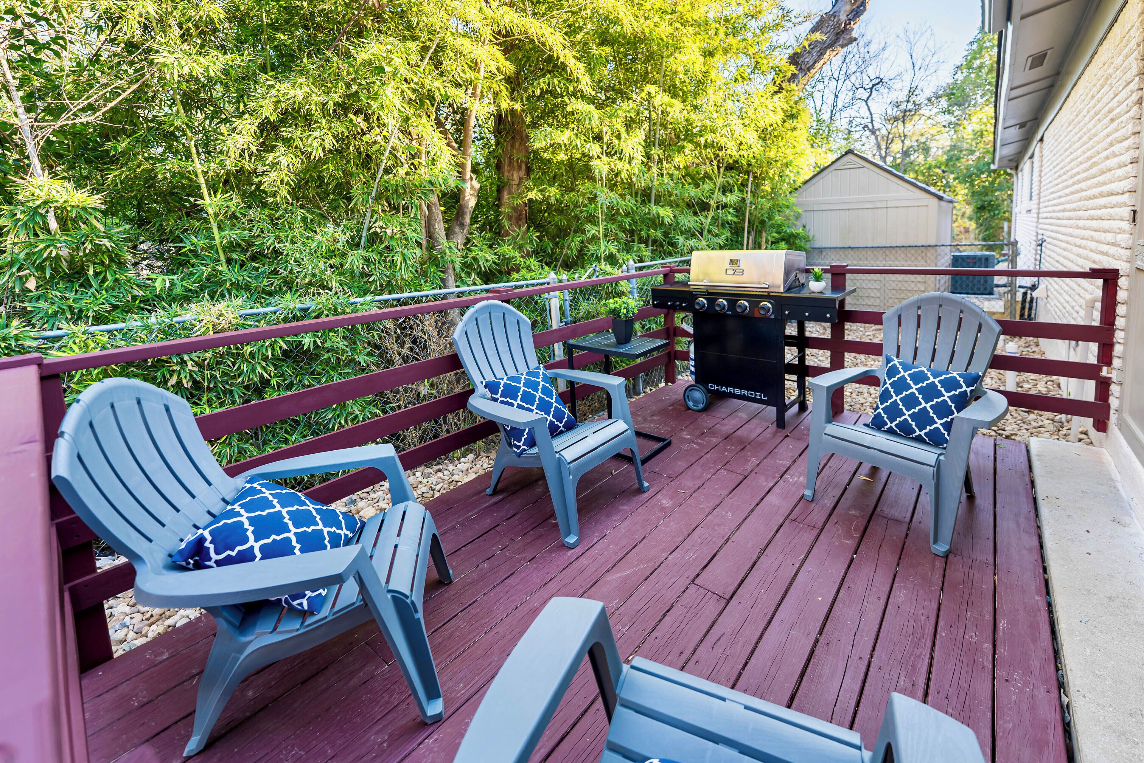 A deck with Adirondack chairs and a grill.
