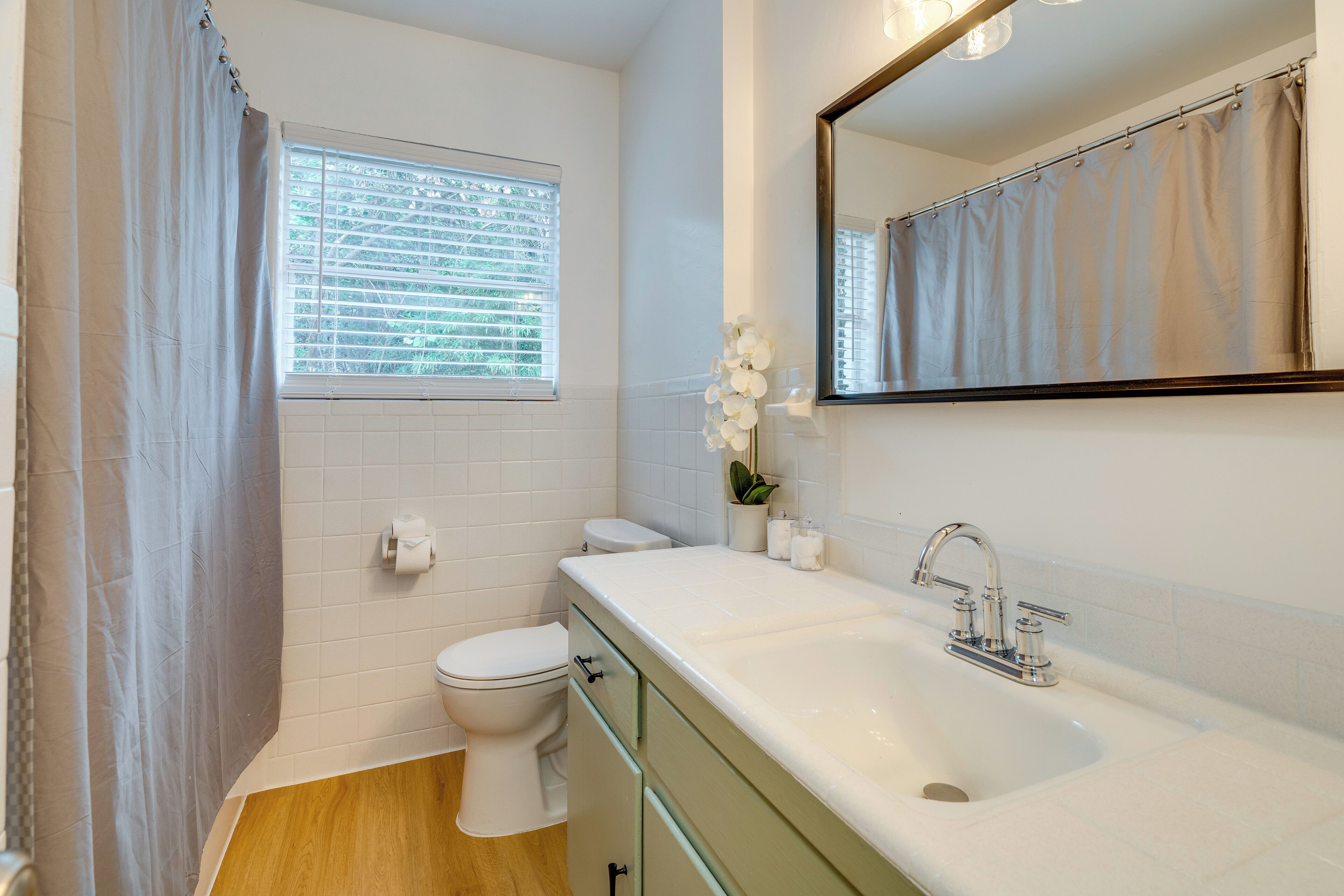 A bathroom with a toilet, sink, and shower curtain.