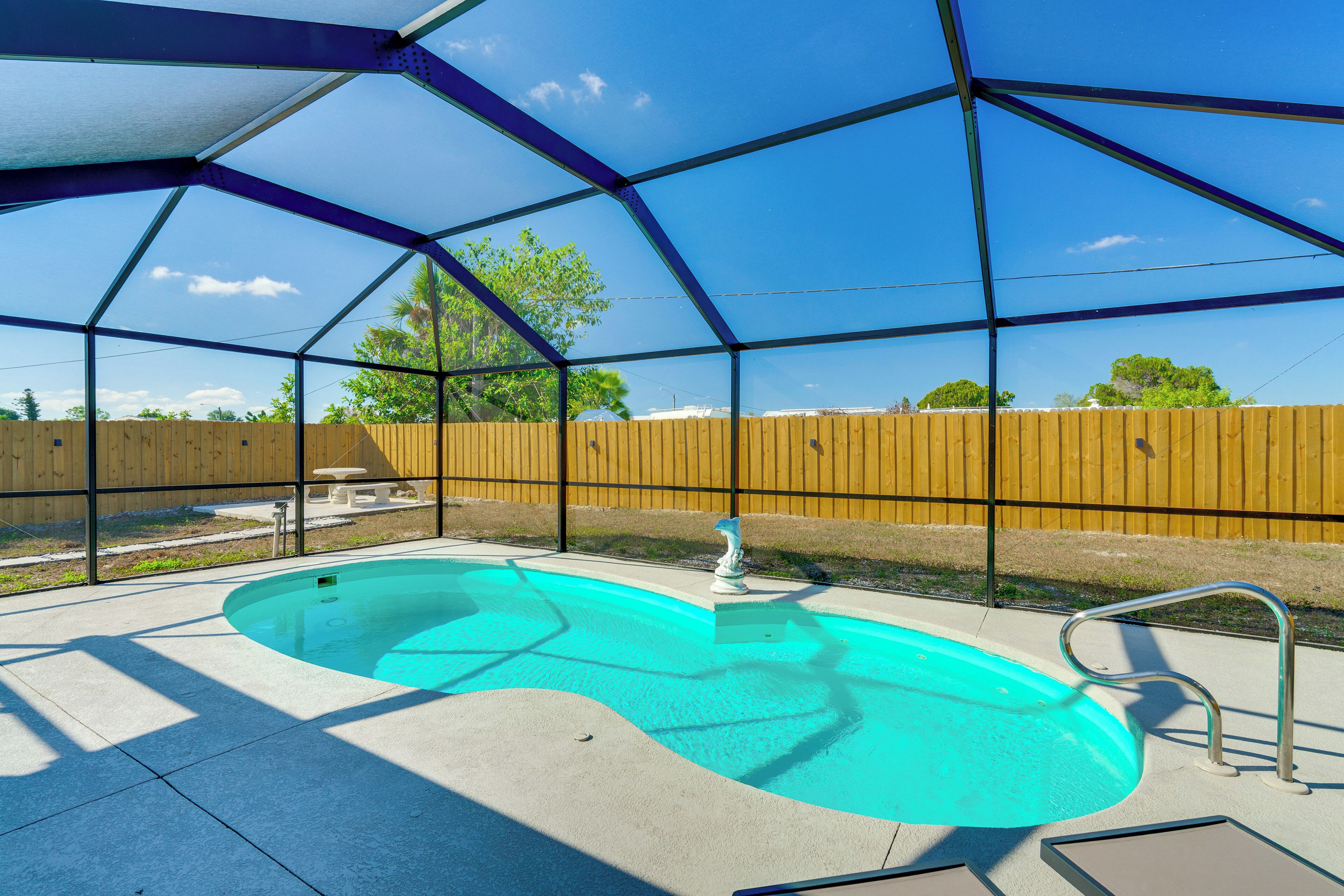 A covered swimming pool with a wooden fence in the background.