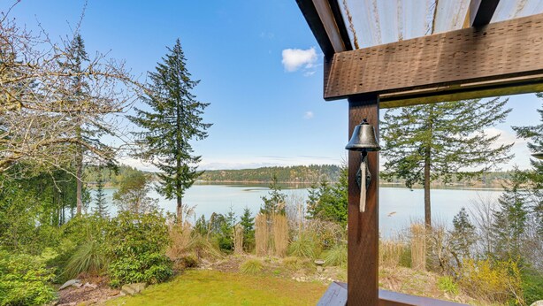 Une terrasse en bois offrant une vue sur un lac et les arbres environnants.