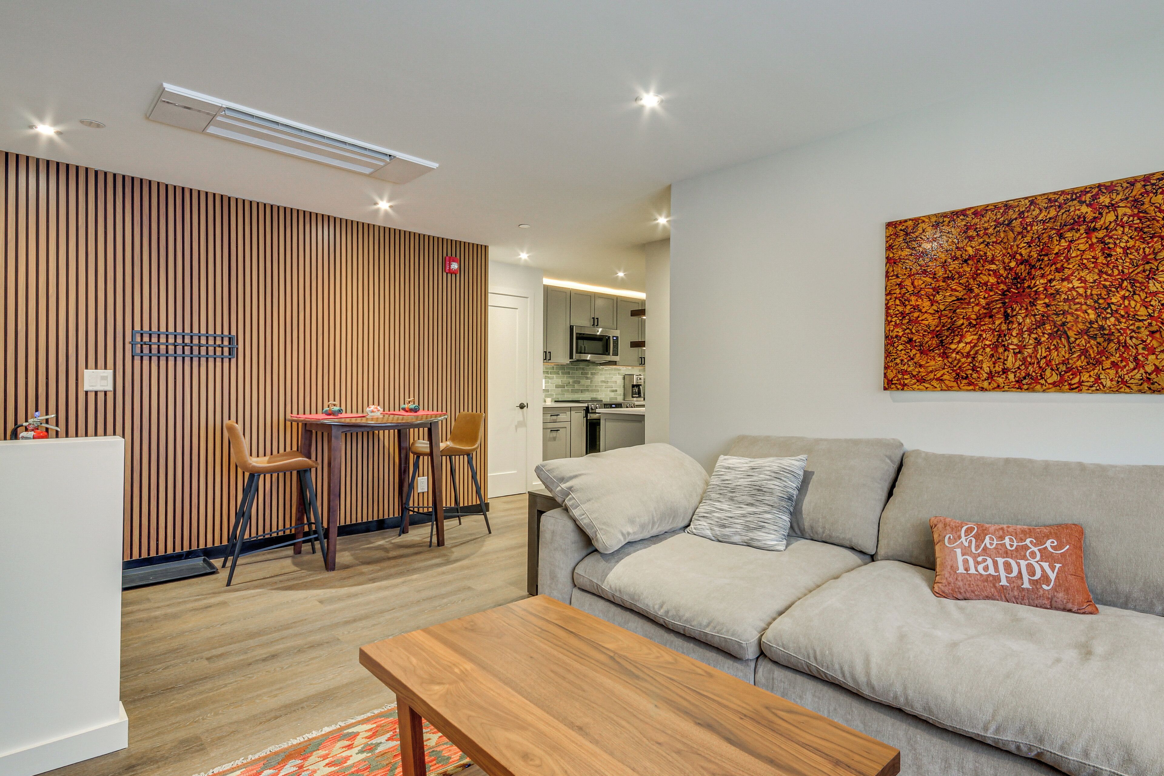 A modern living room with a sofa, a coffee table, and a dining area with a table and chairs.