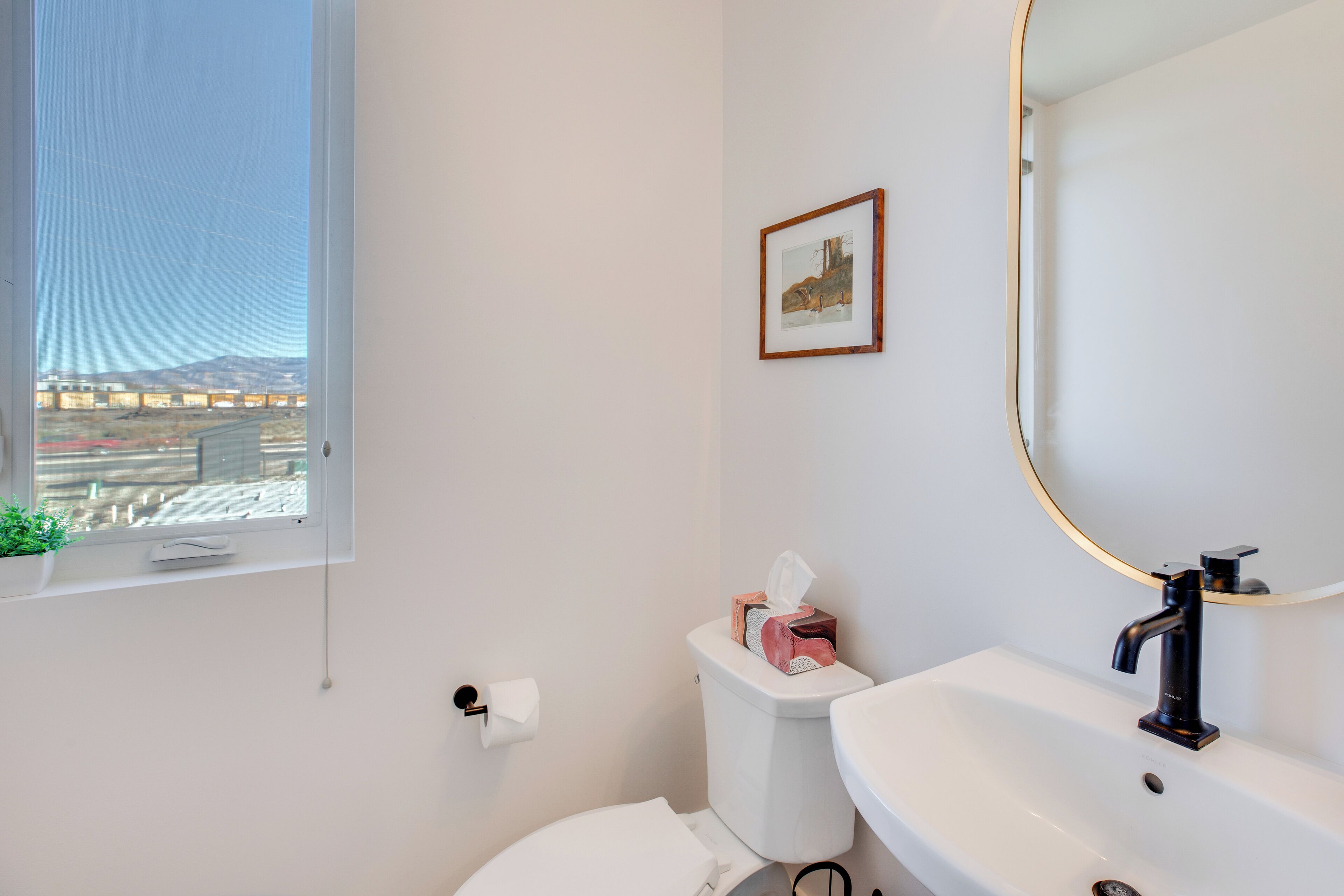 Un baño con inodoro, lavamanos y ventana.