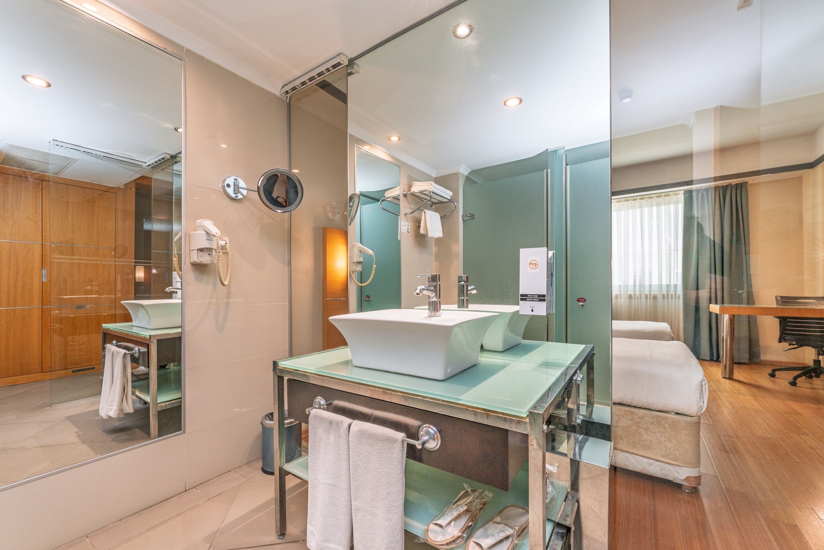 A modern bathroom with a glass-enclosed shower, a large mirror, and a vanity with a sink.