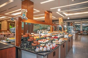 A buffet with various food items and a decorative centerpiece.