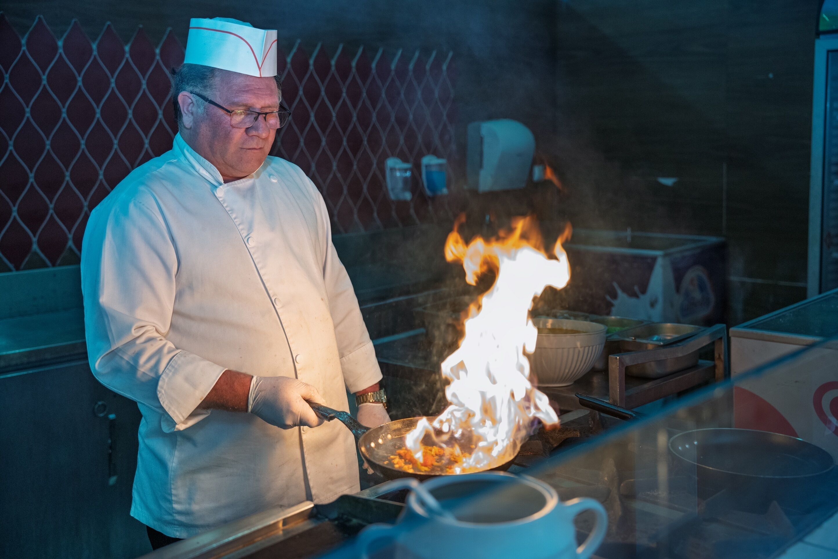 Un chef cocinando sobre una llama en una cocina.