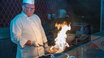 Un chef cocinando sobre una llama en una cocina.