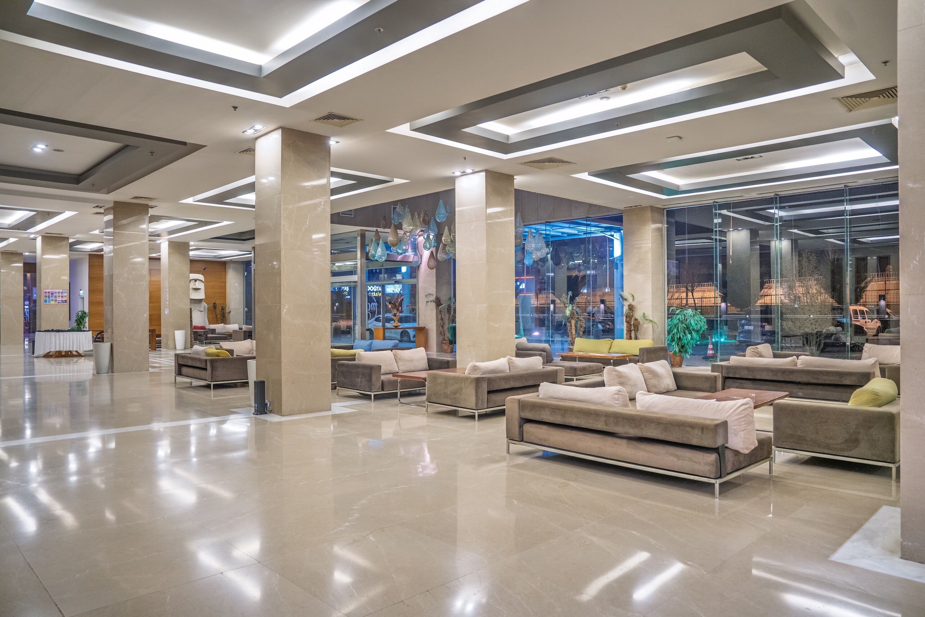 Un lobby amplio con muebles modernos y una gran pared de vidrio que ofrece vistas del interior.