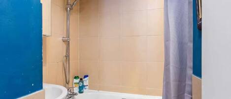 A bathroom with a bathtub, shower, and sink.