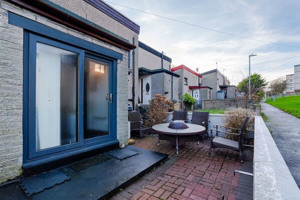 A patio with outdoor furniture, a sliding glass door, and a brick pathway. - 4 Bedroom House - Free Parking (Aberdeen)