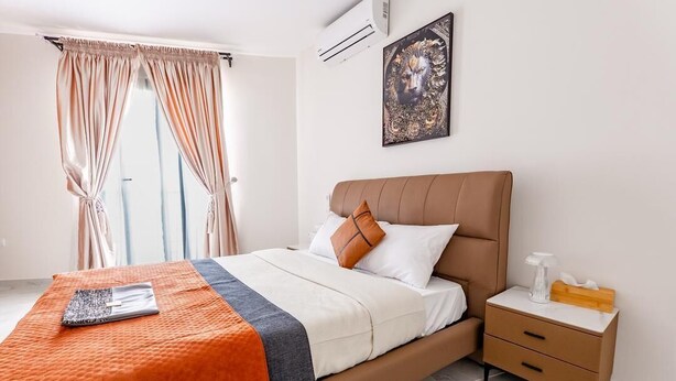A bedroom with a bed, nightstand, and a painting on the wall. - 220 m² apartment with Dakar sea view, 5 minutes from Les Almadies (Dakar)