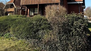 Una casa de dos pisos amb teules vermelles i un balcó de fusta.