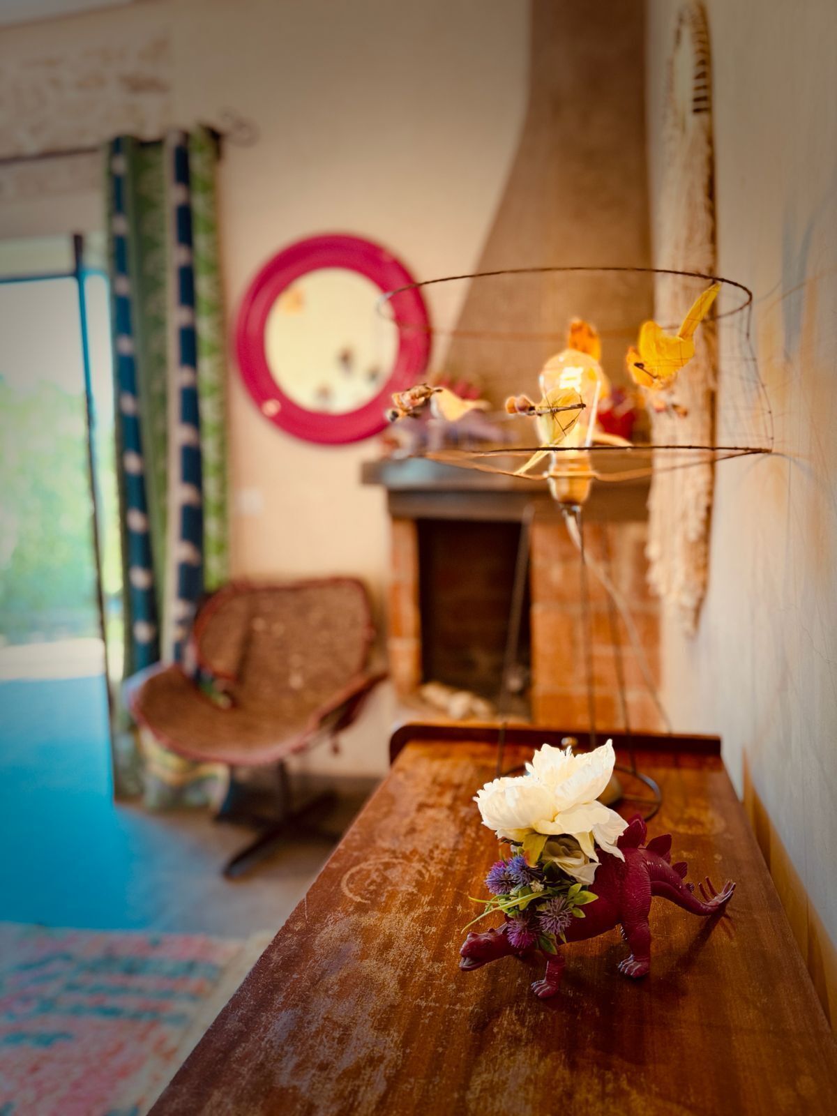 A rustic interior with a wooden table, a mirror, and a chair.