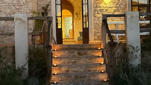 A stone building with a staircase leading to an entrance, surrounded by greenery. - La Villa Sauvage (Ounagha)
