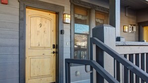 A wooden front door with a number '9' on it, a mailbox, and a small porch with a railing. - Moose Mgmt at Moose Lodge 9: King Beds, Hot Tub, Walk to Skiing (Park City)