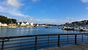 Una località balneare con un molo di legno, barche e case lungo il lungomare.