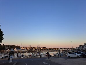 A marina with boats docked, a clear sky, and a few people walking along the dock. - New cottage with ocean views; 3-star vacation rental (Plouhinec)