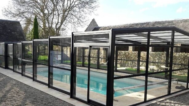 Un espace piscine entouré de parois en verre.
