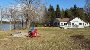 Un chalet au bord du lac, doté d’une terrasse, d’un quai et d’un foyer extérieur.