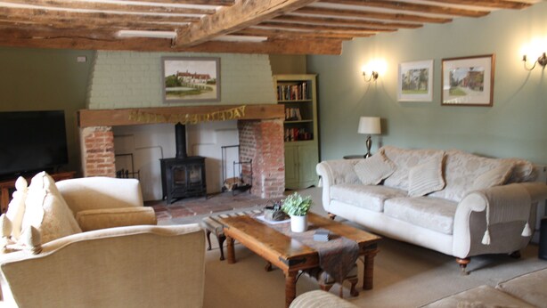 A cozy living room with a fireplace, a sofa, a coffee table, and a bookshelf.