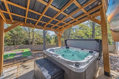 Outdoor spa tub. Hot Tub & Mini Golf · Fenced Yard · Covered Patio for Groups · Sleeps8 · Pets OK