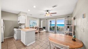 Una cucina con zona pranzo, una ventola a soffitto e vista sull'oceano.