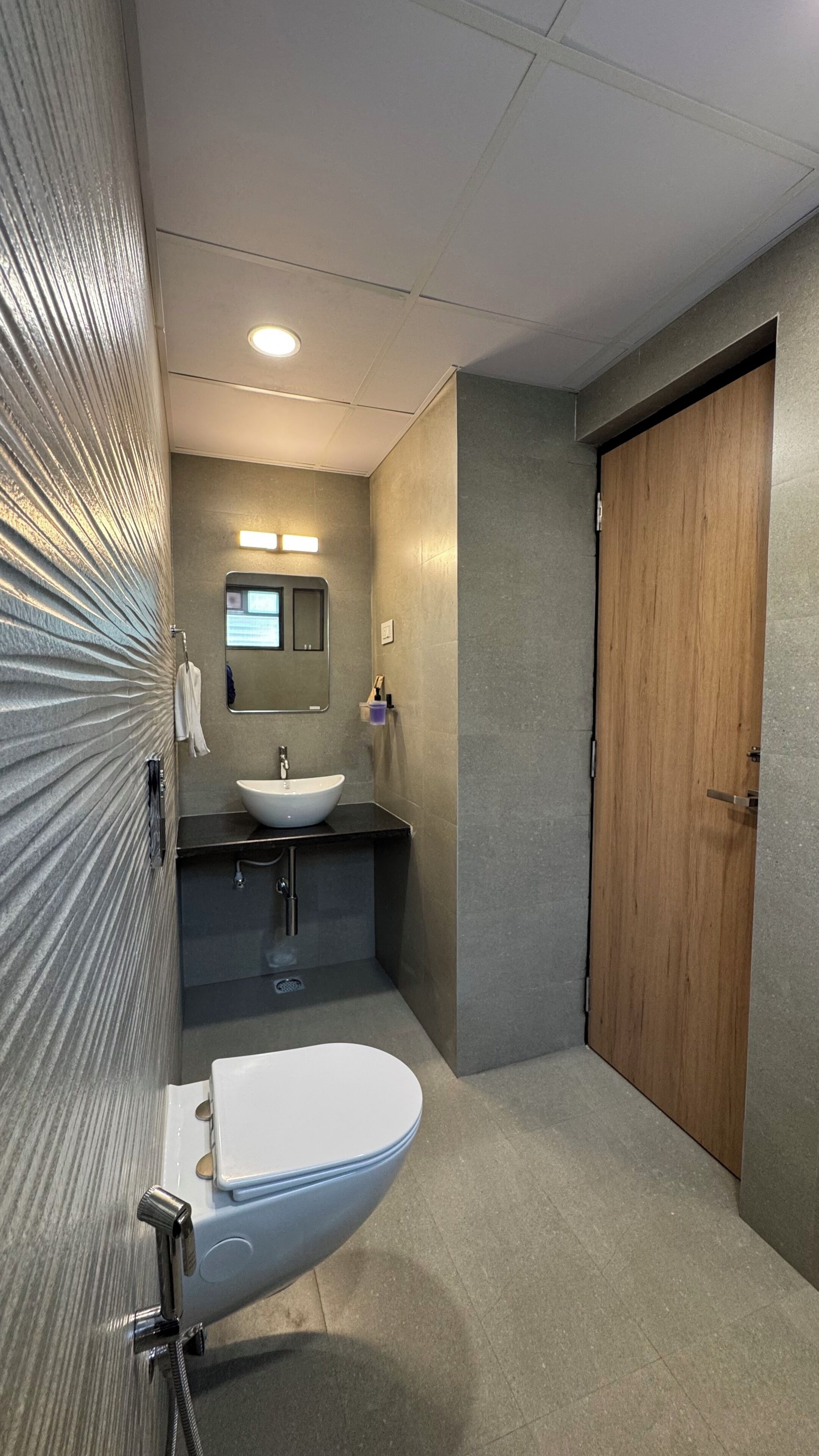 A bathroom with a sink, mirror, and toilet.