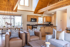 A modern interior with a dining area, sofa, and kitchen.
