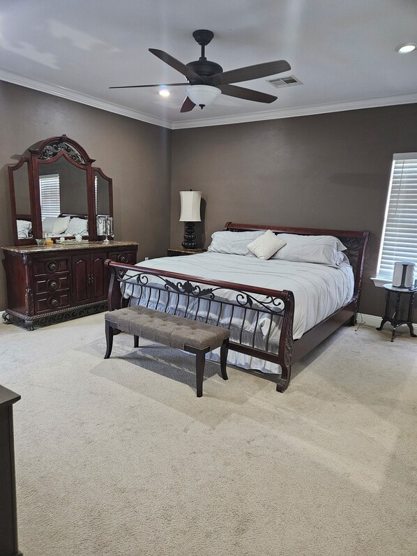 A bedroom with a bed, a bench, a dresser, a mirror, a lamp, and a ceiling fan. - Charming 4-bedroom house with AC in lovely Meraux (Meraux)
