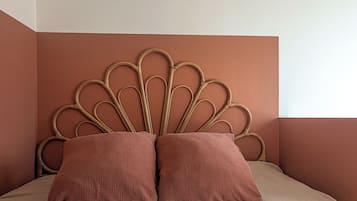 Een bed met een opvallend hoofdbord, twee kussens en een structuurwand.