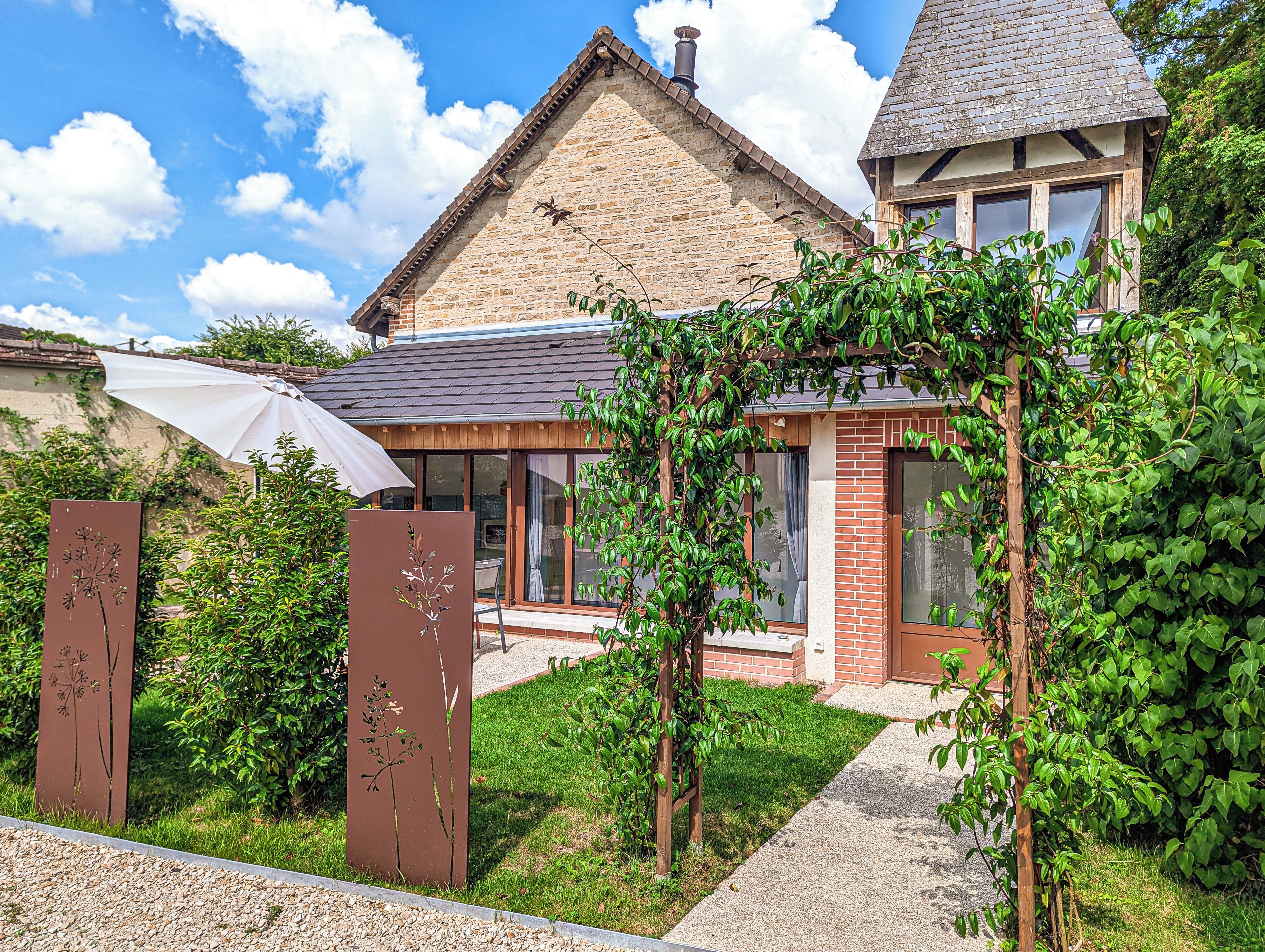 A house with a brick exterior, a wooden porch, and a small garden area.