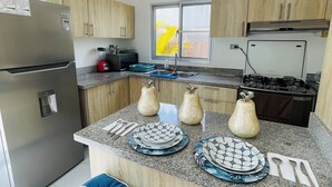 Uma cozinha moderna com bancadas de granito, eletrodomésticos de aço inoxidável e armários de madeira.