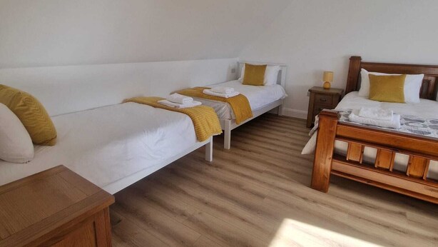 A room with two single beds, a wooden nightstand, and a small table. - Luxurious 4-bedroom house perfect for relaxing stays in Cong (Cong)