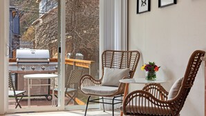 A patio with wicker chairs, a small table, and a grill. - New Listing! Walk to Downtown CDA | Pet-Friendly | Yard + Grill (Coeur D Alene)