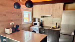 A modern kitchen with a built-in island, stainless steel appliances, and a view of the outside. - Casa del Mediterraneo Apartment in the Old Town of Benidorm (Benidorm)