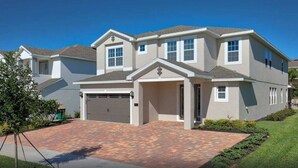 A two-story house with a garage, a driveway, and a well-maintained lawn. - 25% Off 9BR Mansion-Pool/Spa/Games! (Kissimmee)