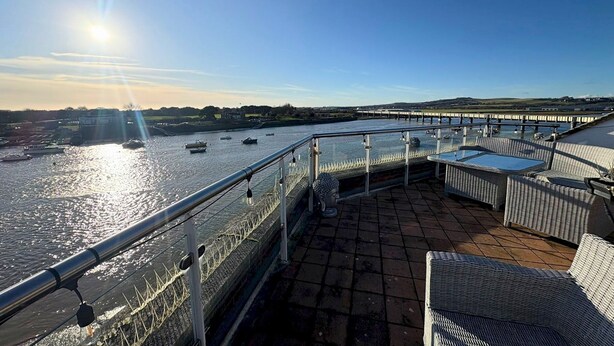 A riverside terrace with wicker furniture and a view of boats on the water. - River Heights With Views Parking |By My Getaways (Brighton)