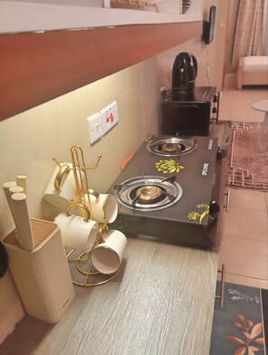 A compact kitchen with a gas stove, a coffee maker, and a small refrigerator. - Fantastic Executive Studio apartment in welcoming Nairobi for your stay (Nairobi)