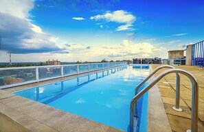 Ein Pool auf dem Dach mit freiem Blick auf die Stadtlandschaft und einem Metallgeländer.