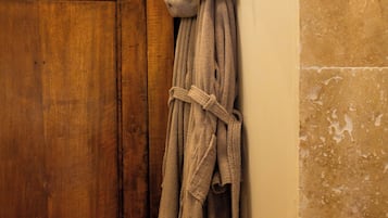 Une armoire en bois, un porte-serviettes avec une serviette, et une paire de chaussons.