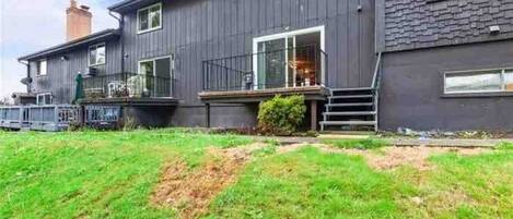 A two-story house with a front porch, a visible chimney, and a grassy yard.