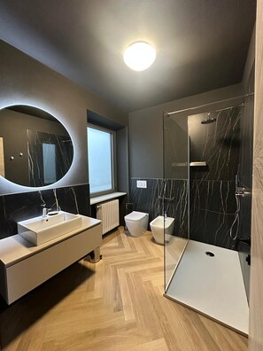 Een douche, een haardroger, een bidet, handdoeken