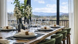 A dining table set for six with a view of the mountains.