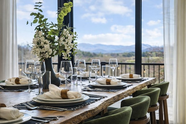 A dining table set for six with a view of the mountains. - Asheville Speakeasy • Heated Pool + Hot Tub • Sauna • Game Room • Sleeps 20 (Weaverville)