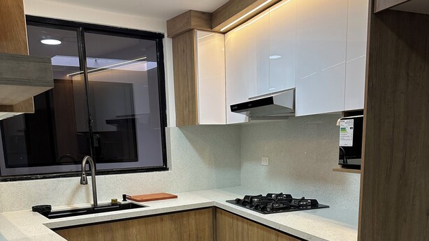 A modern kitchen with wooden cabinets, a stainless steel sink, and a gas stove. - Aero Terminal. Complete apartment very close to the airport and terminal. (Cuenca)
