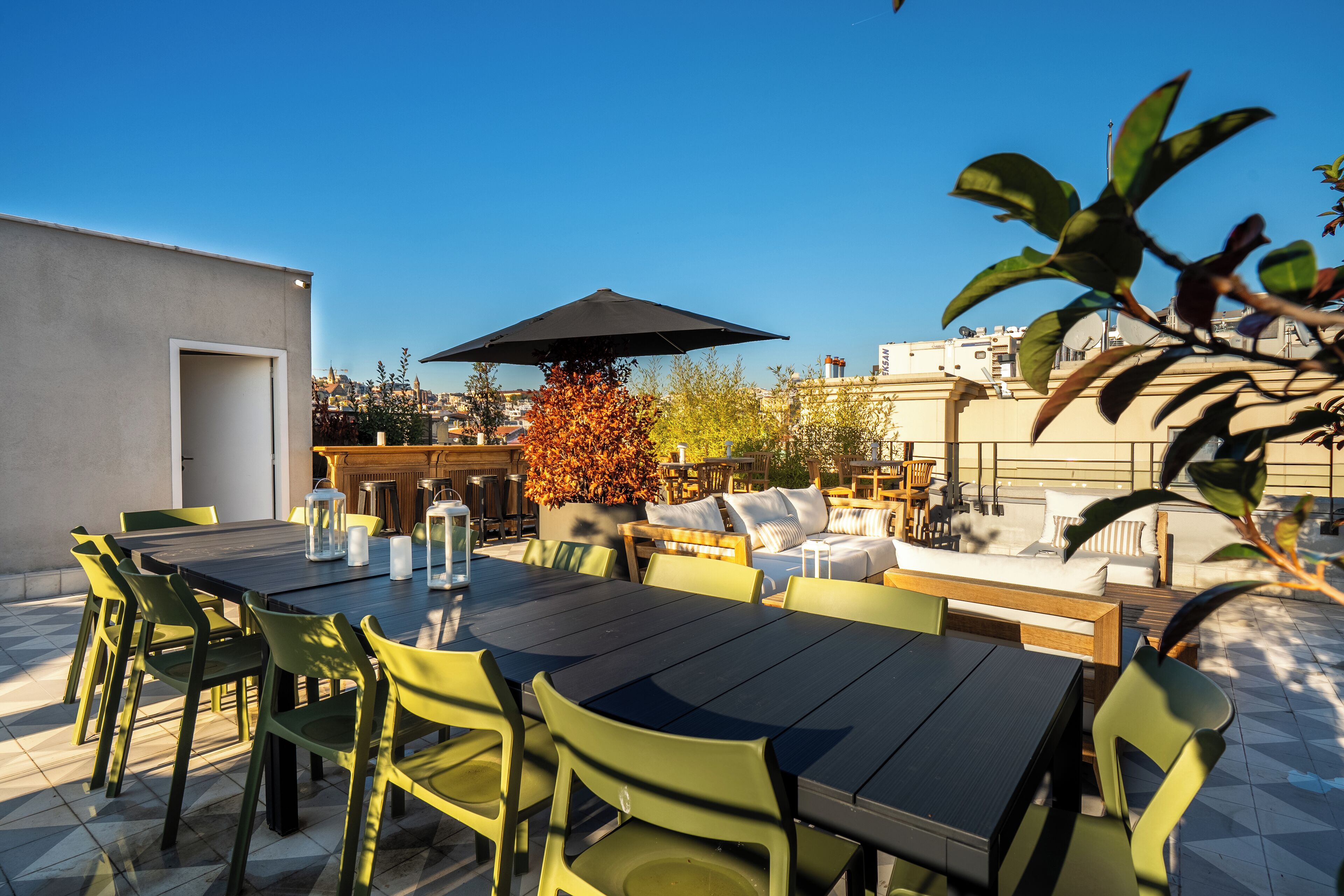 An outdoor patio with a dining table, chairs, and a large umbrella.