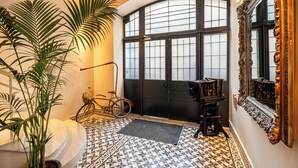 A hallway with a black door, a large mirror, and a bicycle. - The Muradiye Luxury Apartments (Istanbul)